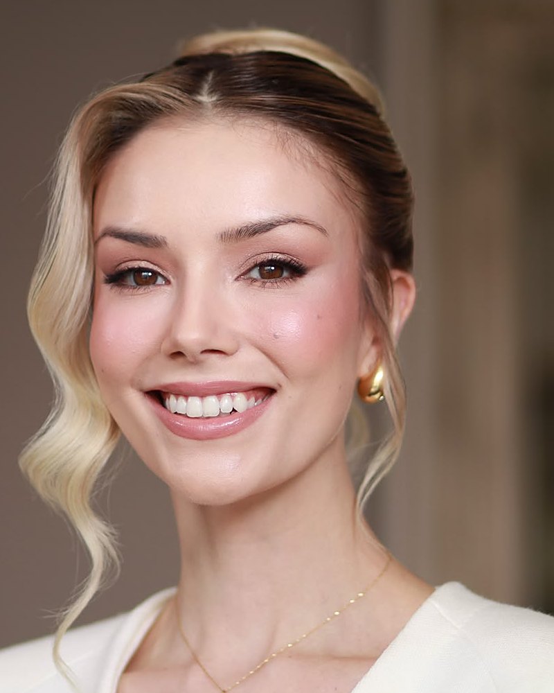 Noiva sorrindo, com maquiagem leve e cabelo preso