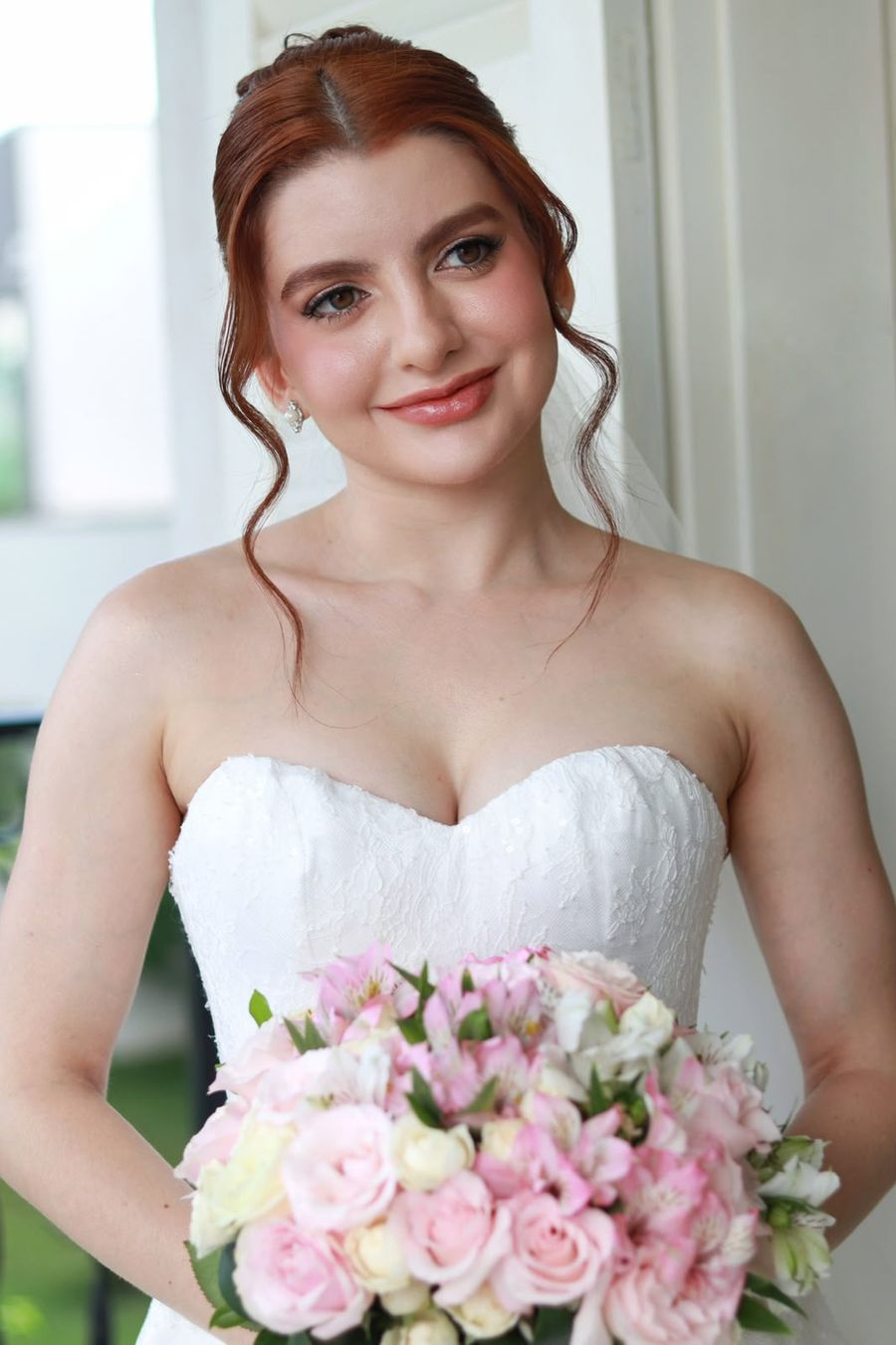 Noiva ruiva com buquê de flores rosa