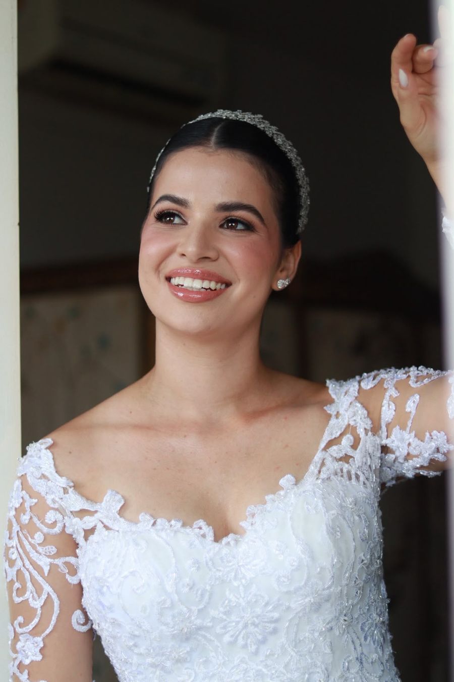 Noiva sorrindo com tiara e vestido de renda
