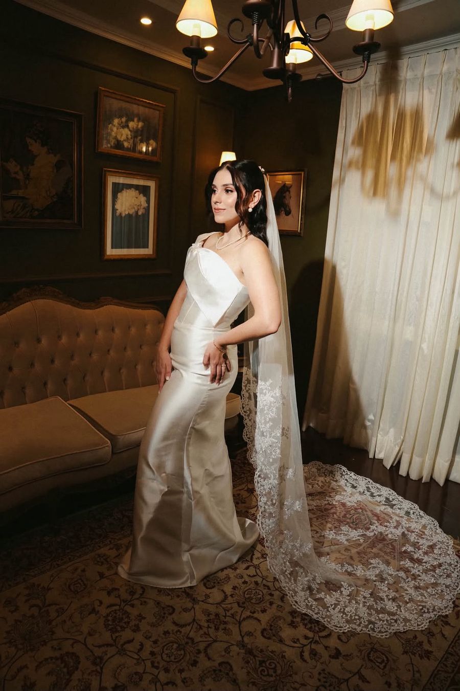 Noiva de vestido longo e véu em sala clássica